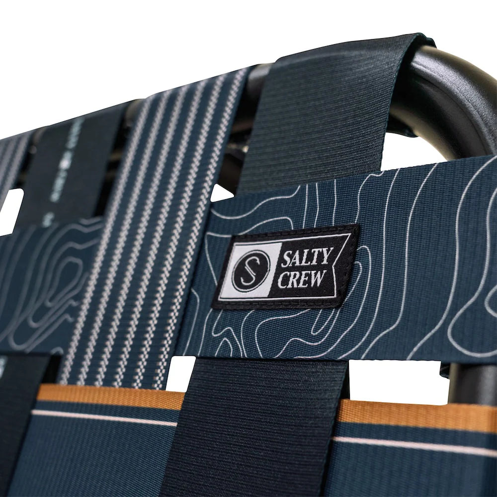 PARKIT x Salty Crew Voyager Chair in limited-edition topo-map pattern, featuring woven webbing, black steel frame, wooden armrests, built-in cooler, cup holder, and backpack straps, rugged 3-in-1 outdoor chair built for surf, fish, and adventure.