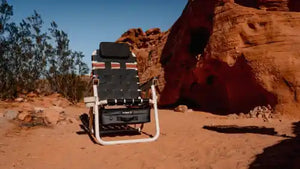 Foldable chair on a rocky desert landscape with red rock formations.